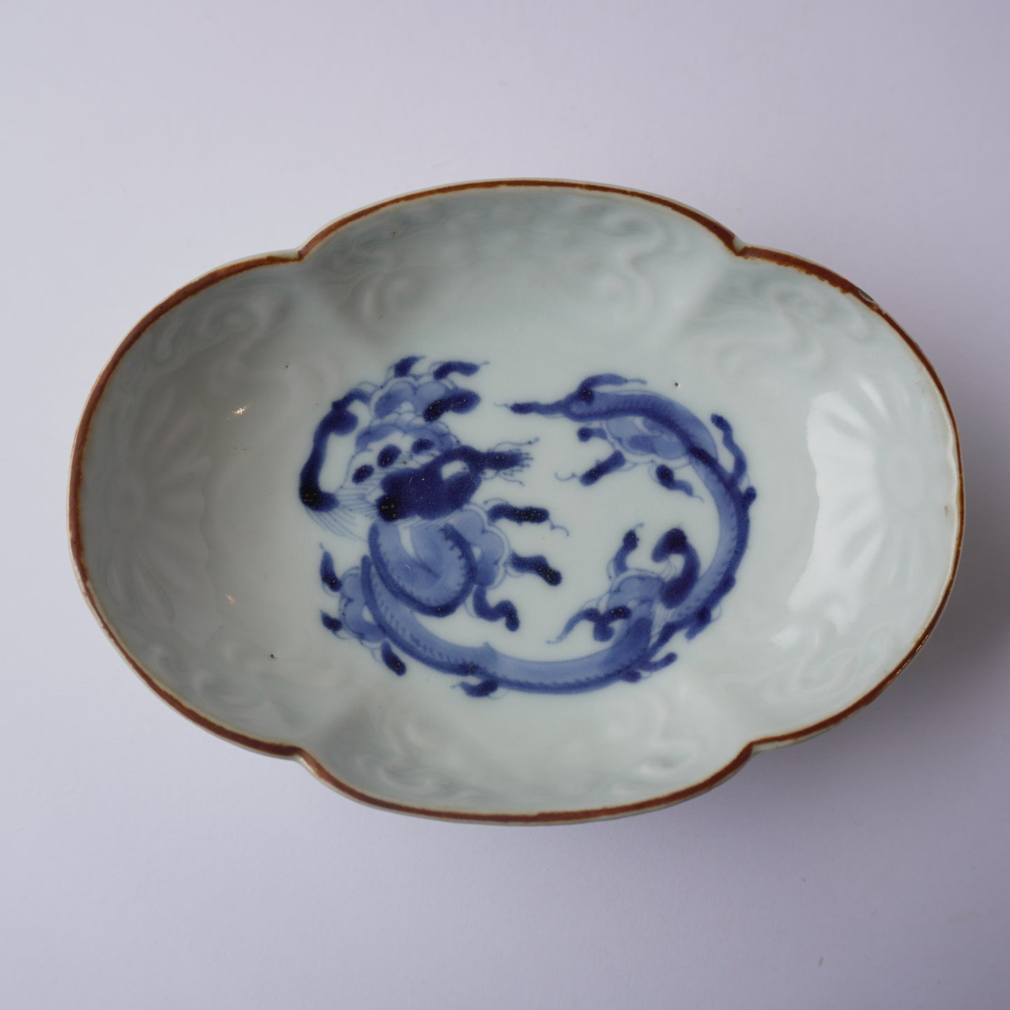 龍と茶色の縁の陽刻染付け小皿