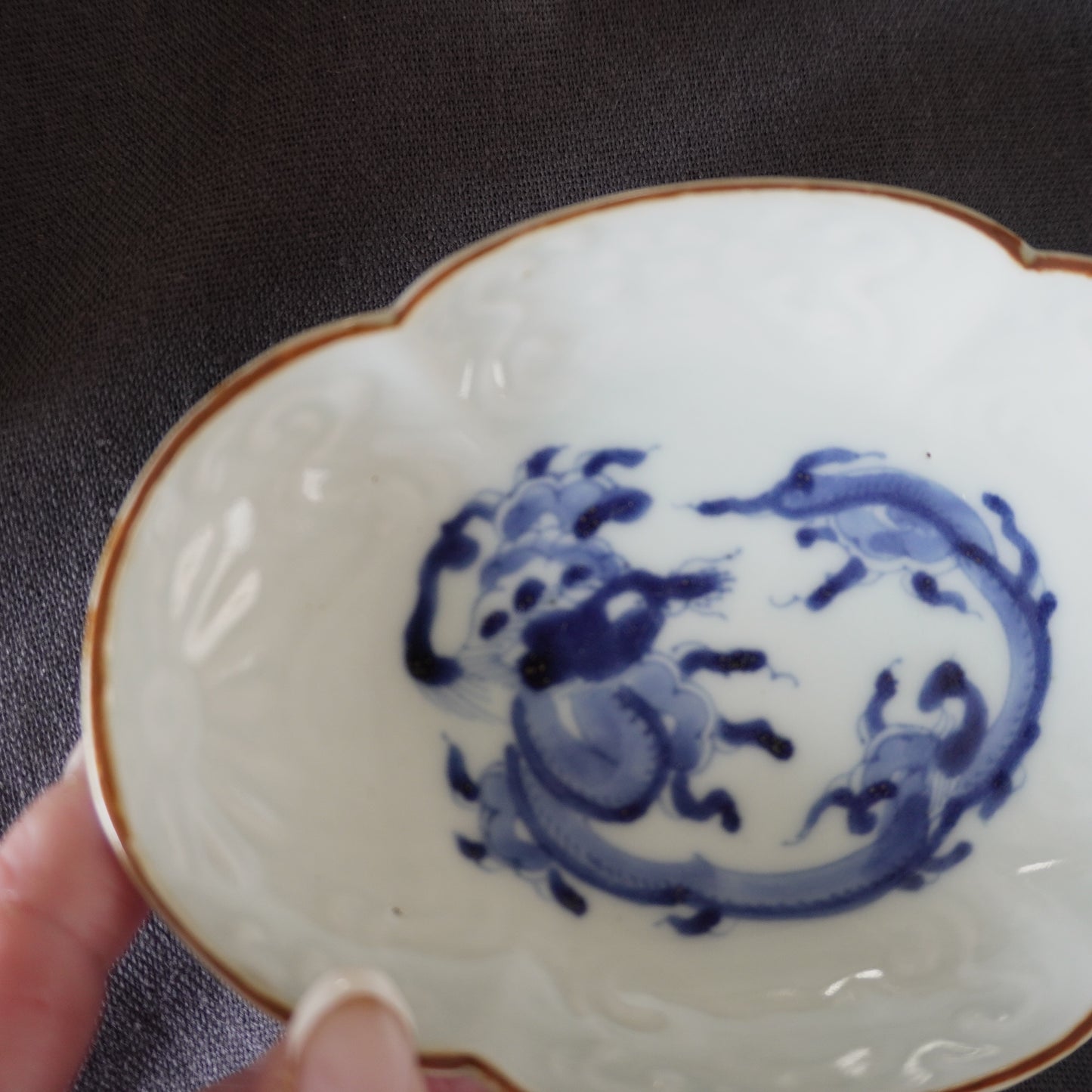 龍と茶色の縁の陽刻染付け小皿